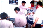 Lekhadeepans keenly engaged at the job work of filling, weighing and sealing seed pouches for Zuvari Seeds Corporation, click here to see large picture.