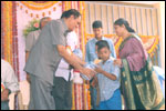 Special School student Mr M. Anudeep, receives a prize from Sri C. V. Avadhani, Principal AG Others await their turn., click here to see large picture.